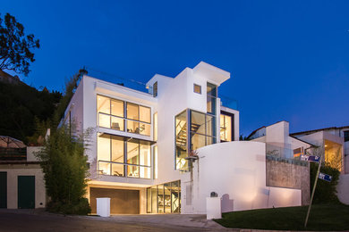Diseño de fachada blanca moderna grande de tres plantas con revestimiento de estuco