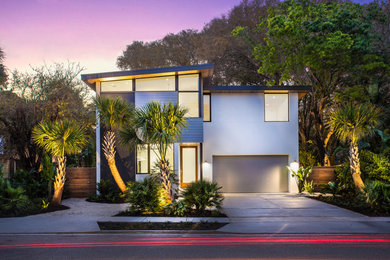 Idées déco pour une petite façade de maison grise moderne à un étage avec un revêtement mixte et un toit en appentis.