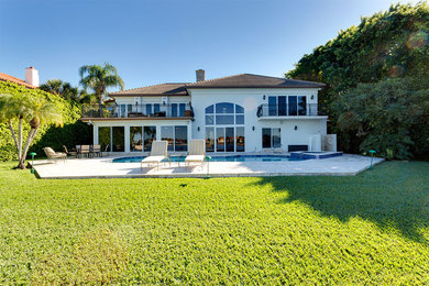 Mid-sized tuscan white two-story concrete house exterior photo in Other with a hip roof and a shingle roof