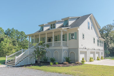 Example of a mid-sized beach style white two-story wood exterior home design in Charleston with a shingle roof