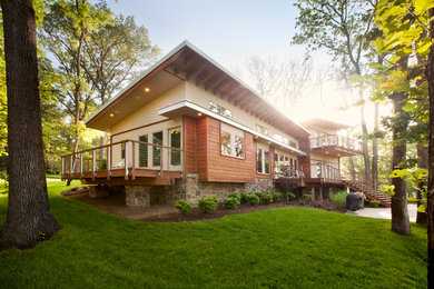 Foto de fachada de casa beige actual grande de dos plantas con revestimientos combinados y tejado de un solo tendido