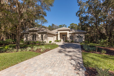 Inspiration for a large transitional beige one-story concrete exterior home remodel in Orlando