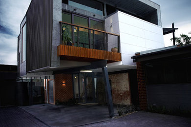 Foto de fachada contemporánea pequeña de dos plantas con revestimientos combinados y tejado plano