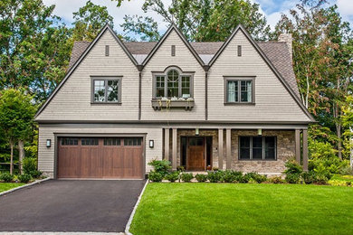 Large cottage chic beige two-story brick exterior home photo in New York with a clipped gable roof