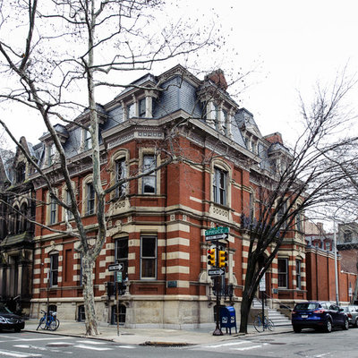 Huge traditional red three-story brick flat roof idea in Philadelphia
