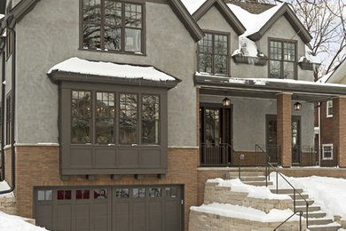 Photo of a medium sized and beige classic two floor render house exterior in Minneapolis with a half-hip roof.