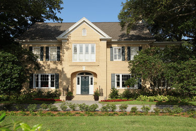 Immagine della villa grande beige classica a due piani con rivestimento in mattoni, tetto a capanna e copertura a scandole