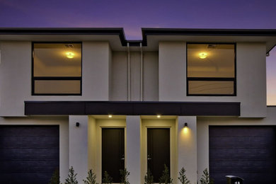 Ejemplo de fachada de casa pareada blanca contemporánea de tamaño medio de dos plantas con tejado de metal