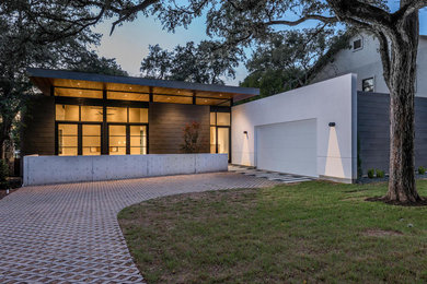 Inspiration for a large modern two-story metal flat roof remodel in Austin