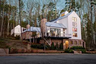 Mid-sized farmhouse white three-story stone exterior home idea in Atlanta with a metal roof