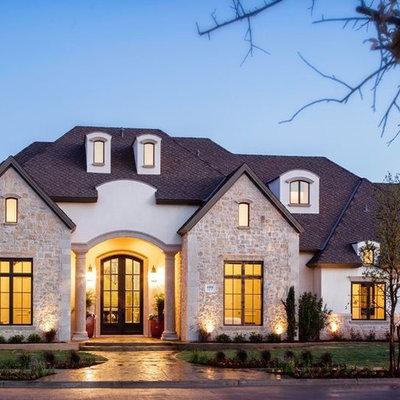 Example of a large classic white two-story stucco exterior home design in Austin with a shingle roof