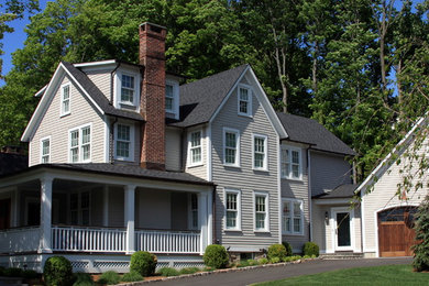 Example of a mid-sized classic beige three-story wood exterior home design in New York with a shingle roof