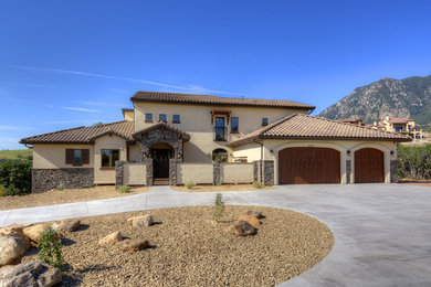 Inspiration for a mediterranean beige two-story stucco exterior home remodel in Denver