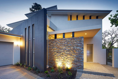На фото: двухэтажный, серый дом в современном стиле с плоской крышей