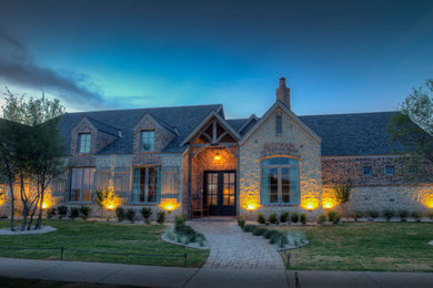 Example of a large mountain style beige one-story stone exterior home design in Austin