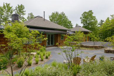 Example of a mid-sized mountain style brown one-story wood house exterior design in Boston with a hip roof and a shingle roof