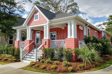 Example of a small arts and crafts red one-story concrete fiberboard house exterior design in Wilmington with a hip roof and a shingle roof
