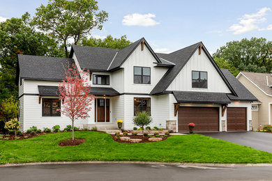 Exemple d'une grande façade de maison blanche chic à un étage avec un toit en shingle et un toit à deux pans.