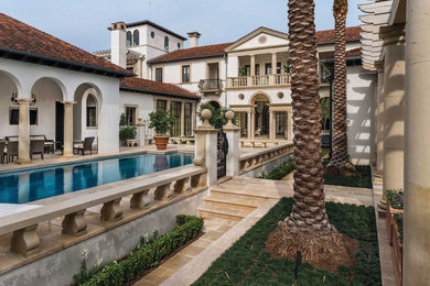 Huge mediterranean beige two-story stone house exterior idea in New Orleans