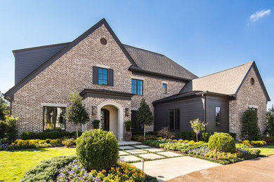 Transitional two-story brick house exterior idea in Other with a shingle roof