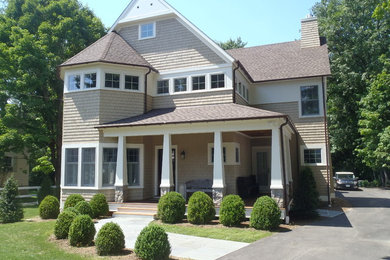 Large elegant beige three-story wood exterior home photo in New York with a shingle roof