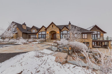 Huge elegant beige one-story stone exterior home photo in Calgary