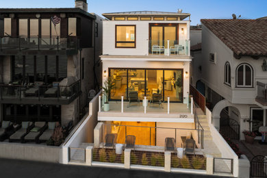 Inspiration for a tropical white three-story house exterior remodel in Los Angeles