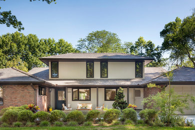 Inspiration for a modern beige mixed siding exterior home remodel in Kansas City with a hip roof