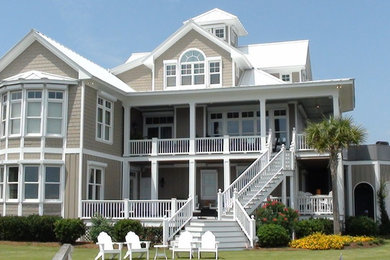 Huge beach style beige three-story wood gable roof photo in Other
