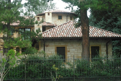 Imagen de fachada de casa multicolor mediterránea grande de dos plantas con revestimientos combinados y tejado de teja de barro