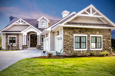 Cette photo montre une façade de maison beige chic à un étage et de taille moyenne avec un toit à deux pans, un revêtement mixte et un toit en shingle.