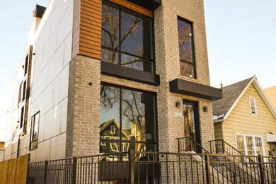 Example of a large trendy gray three-story mixed siding flat roof design in Chicago