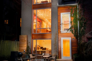 Imagen de fachada gris contemporánea de tamaño medio de tres plantas con revestimiento de madera y tejado plano