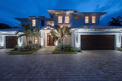 Example of a large transitional white two-story concrete fiberboard exterior home design in Miami with a hip roof