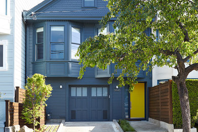 Modelo de fachada de casa azul clásica pequeña de dos plantas con revestimiento de madera y tejado a dos aguas