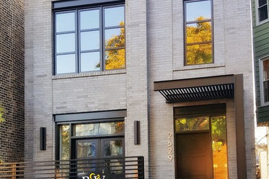 Example of a trendy gray three-story brick exterior home design in Chicago