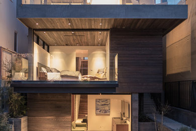 Imagen de fachada de casa marrón contemporánea de tres plantas con revestimiento de madera y tejado plano
