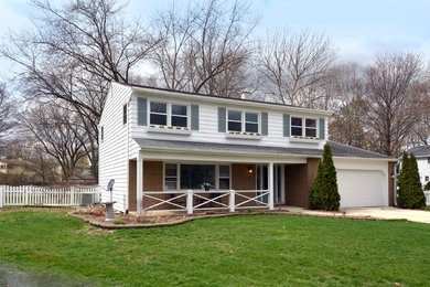 Foto de fachada de casa blanca clásica de dos plantas con revestimientos combinados, tejado a dos aguas y tejado de teja de madera