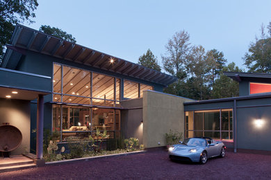 Foto på ett mycket stort funkis flerfärgat hus, med allt i ett plan, blandad fasad, pulpettak och tak i metall