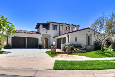 Large elegant white two-story stucco exterior home photo in Orange County