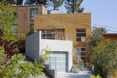 Ejemplo de fachada marrón moderna grande de dos plantas con revestimiento de madera y tejado plano
