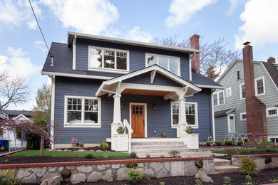 Imagen de fachada de casa azul de estilo americano grande de dos plantas con revestimiento de madera, tejado a dos aguas y tejado de teja de madera