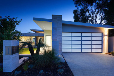 Imagen de fachada de casa gris moderna grande de una planta con revestimiento de estuco, tejado plano y tejado de metal