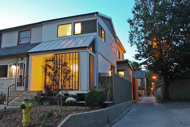 Ejemplo de fachada blanca moderna de tamaño medio de dos plantas con revestimiento de estuco y tejado a dos aguas
