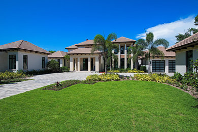 Large transitional beige two-story stucco exterior home idea in Miami