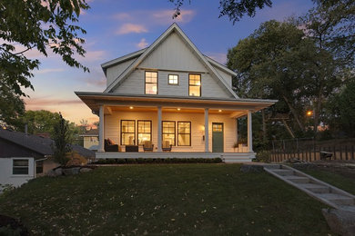 Foto de fachada blanca de estilo de casa de campo grande de dos plantas con revestimiento de aglomerado de cemento y tejado a dos aguas