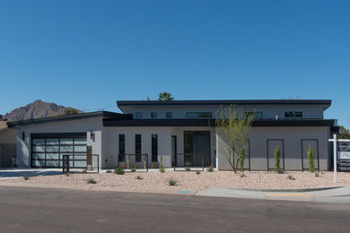 Ejemplo de fachada de casa blanca urbana de tamaño medio de una planta con revestimiento de estuco y tejado de metal