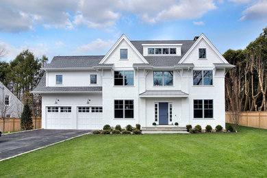Example of a large classic white three-story wood exterior home design in New York with a shingle roof