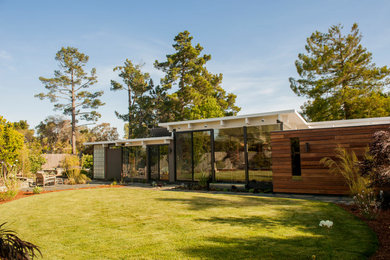 Foto de fachada de casa marrón contemporánea de tamaño medio de una planta con revestimiento de madera, tejado plano y tejado de varios materiales