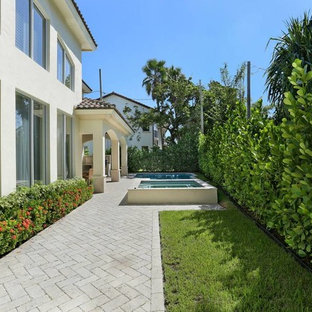 Foto de fachada de casa beige, mediterránea, de tamaño medio, de dos plantas, con revestimiento de hormigón, tejado a cuatro aguas y tejado de teja de madera